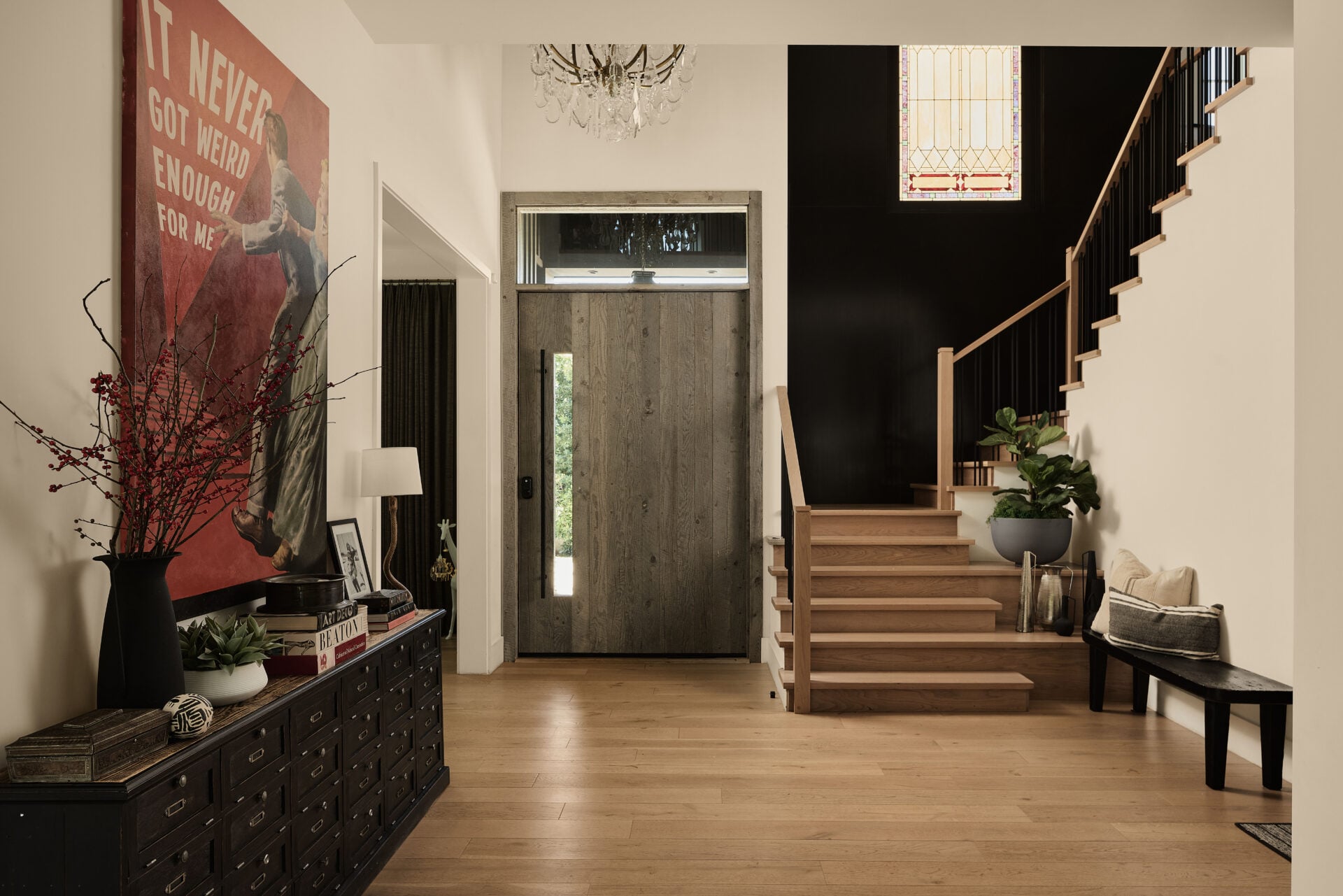 The foyer of Blackbear's house with a light wood staircase next to the front door.