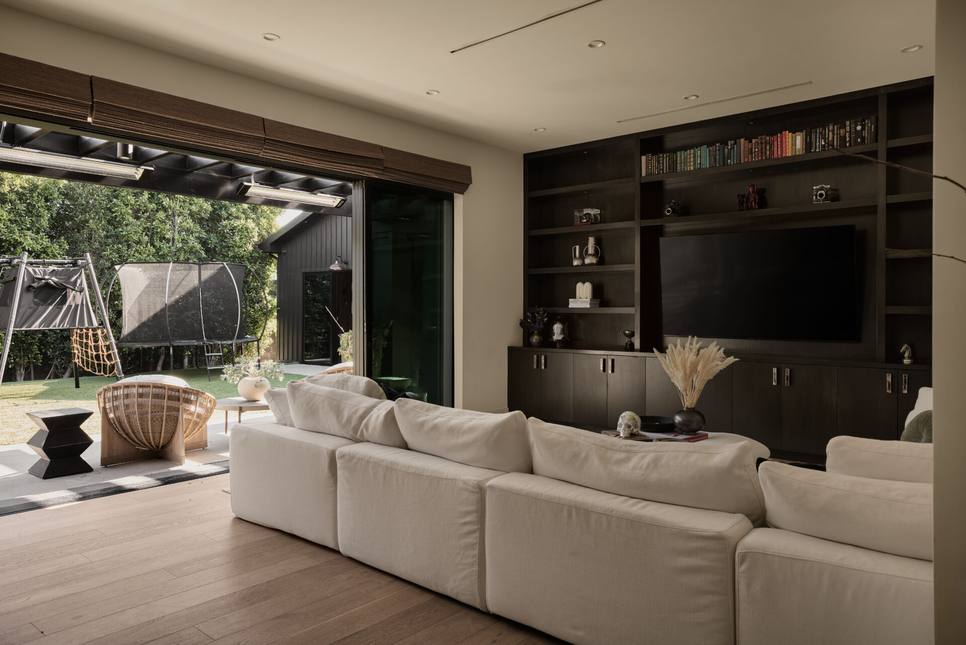 Family room with a deep sectional positioned to face a wall of dark built-ins that frame the TV.