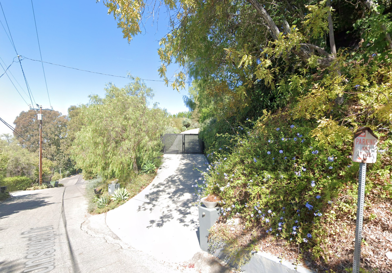 Gated entrance to Olivia Wilde's Studio City house on a winding road.