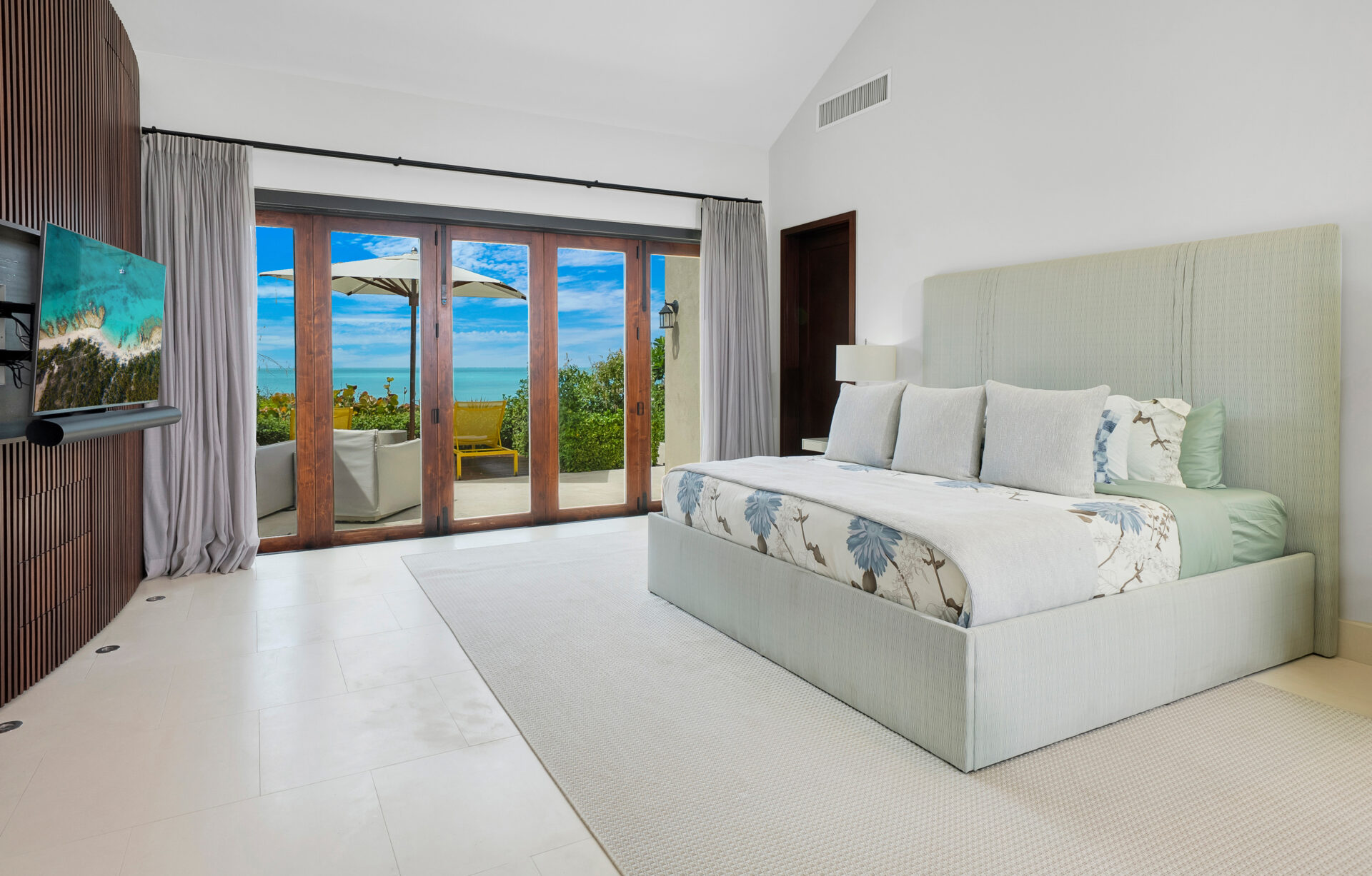 Bedroom with upholstered bed, muted tones, and a large amount of space