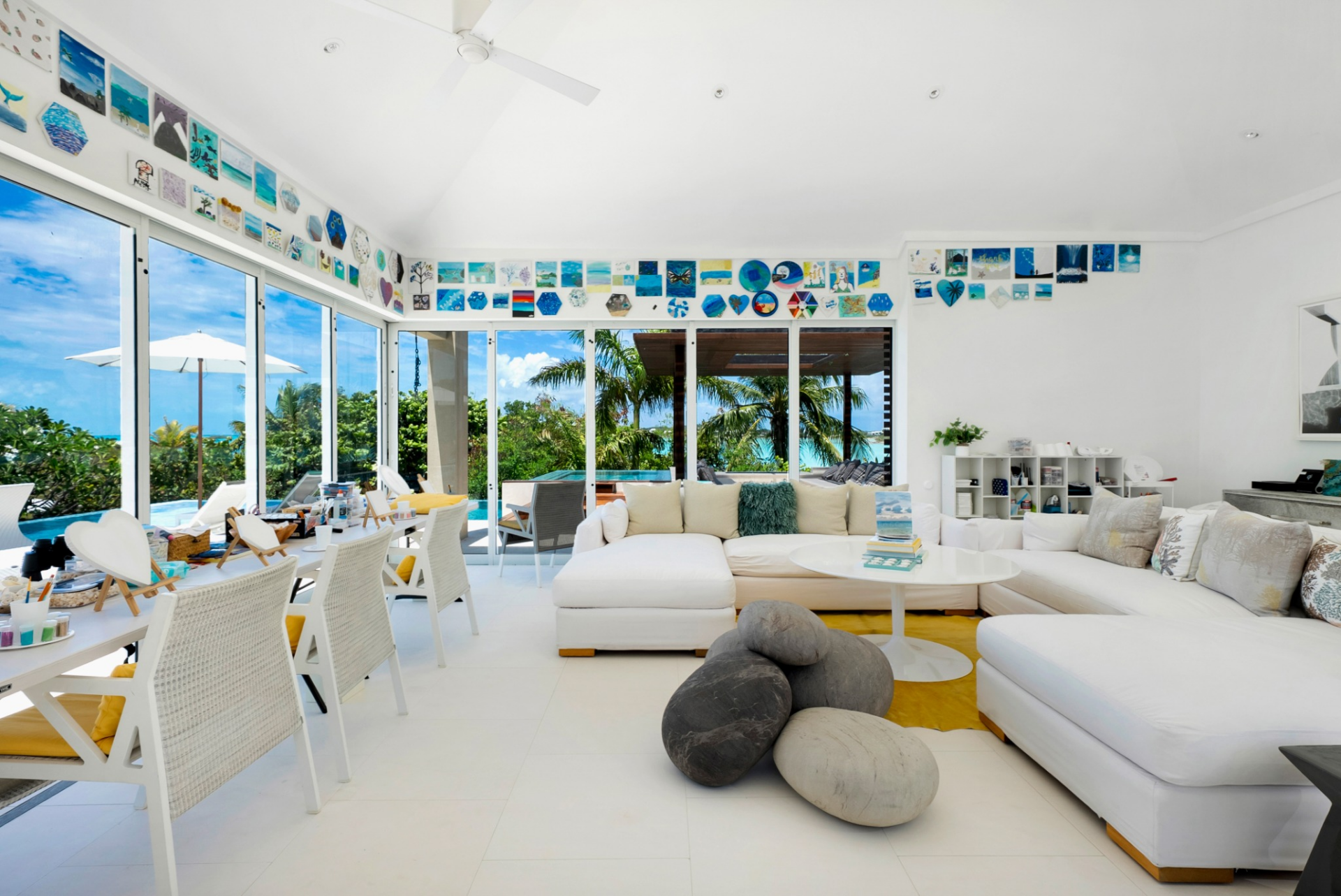 The art room is bright and expansive, lined with oversized sliding glass doors that open to lush outdoor views.