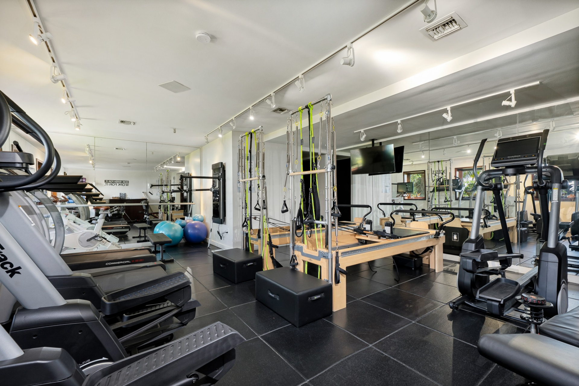 The gym is fully equipped to be its own fitness studio, featuring cardio machines, weight training equipment, and Pilates reformers.