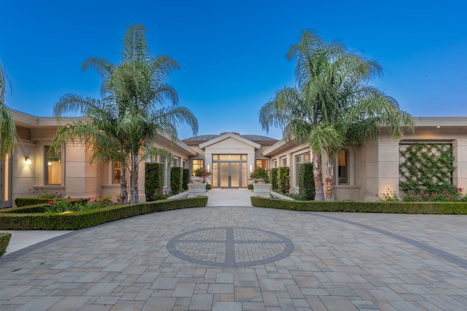 Single story home entrance on a brick driveway.