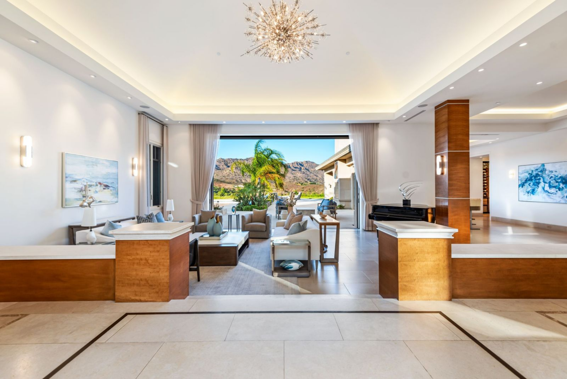 Imported stone floor steps guide you you into the formal living room with a piano and seating.