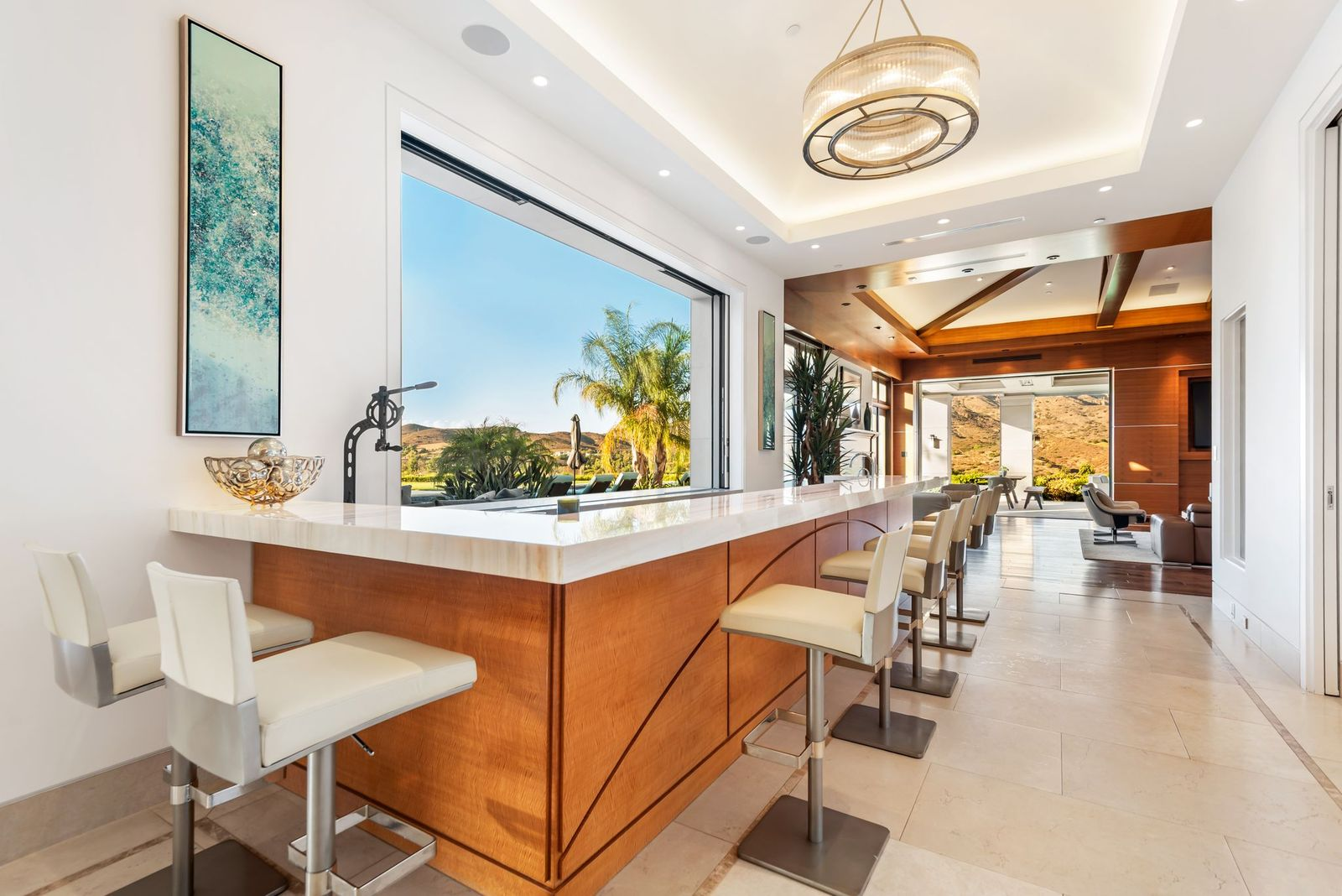 An onyx wet bar stretches along the length of a full pass-through window that slides open to the pool area.