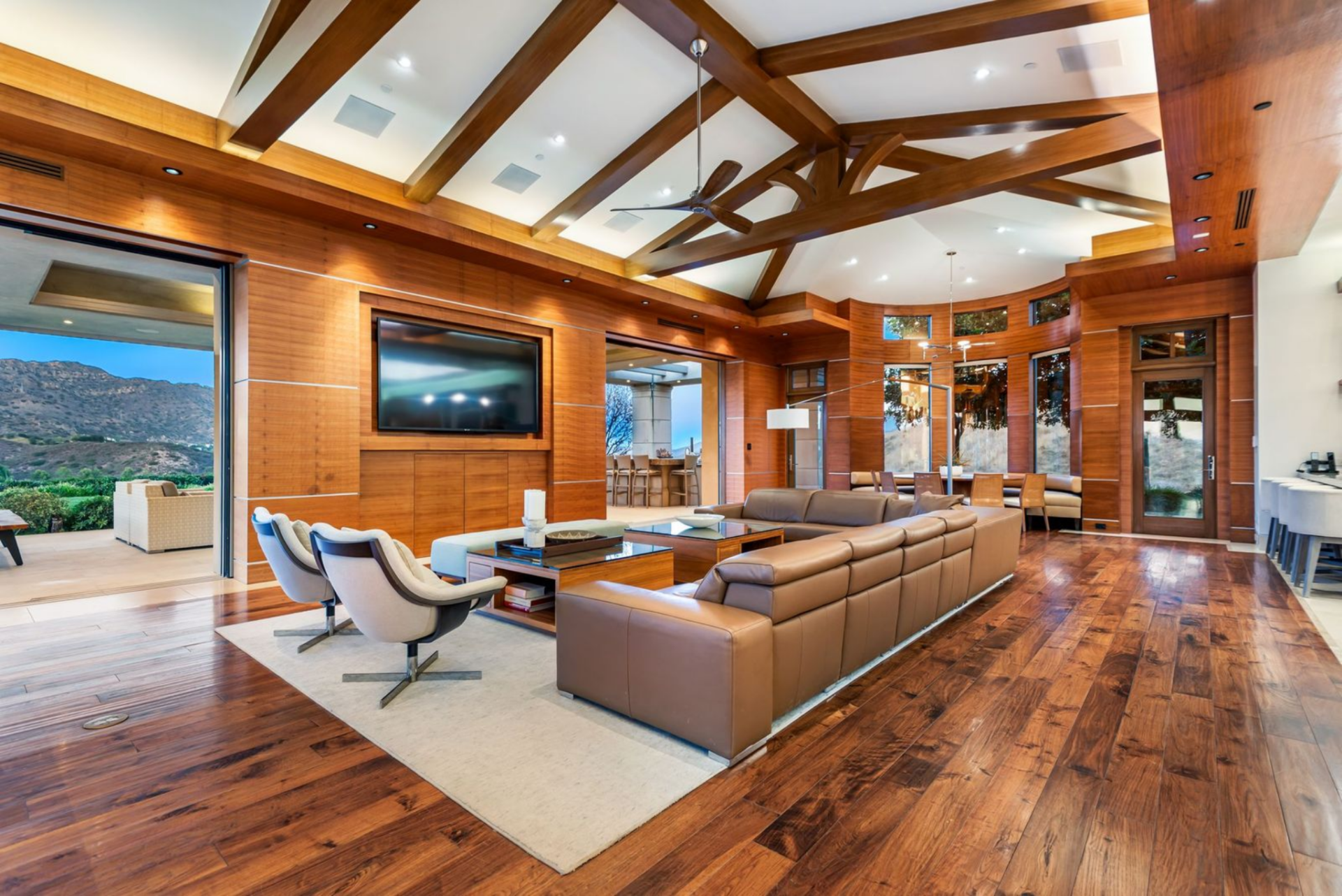 Media lounge is a wood-wrapped space with rich walnut floors and exposed ceiling beams.