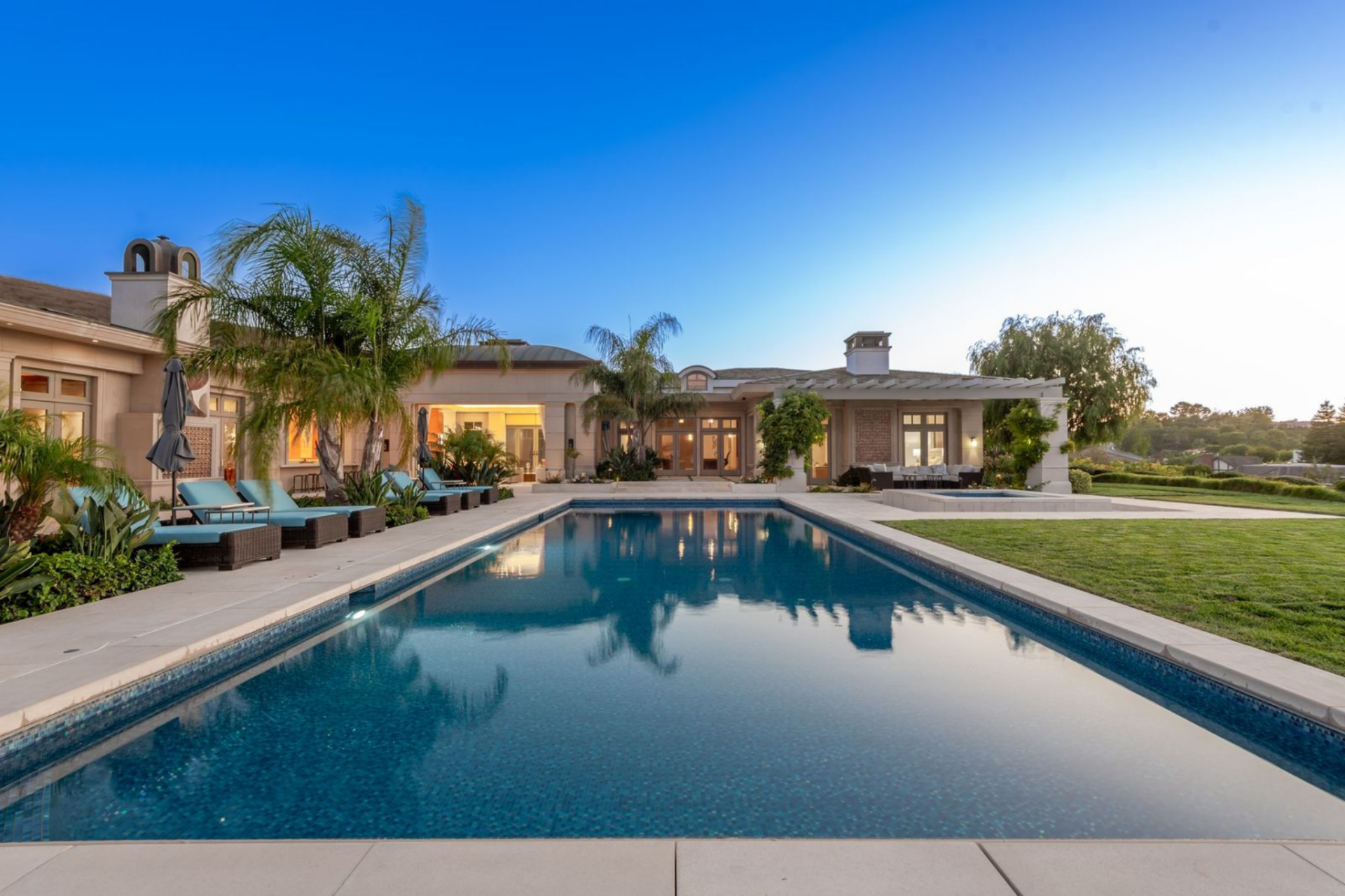 A custom mosaic-tiled pool and spa with a deep blue finish reflecting the sky.