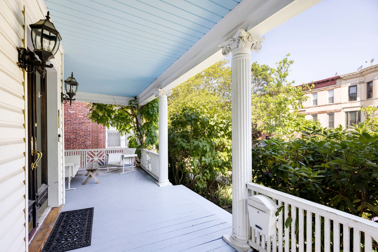 Front porch that stretches the length of a Victorian house in Brooklyn.