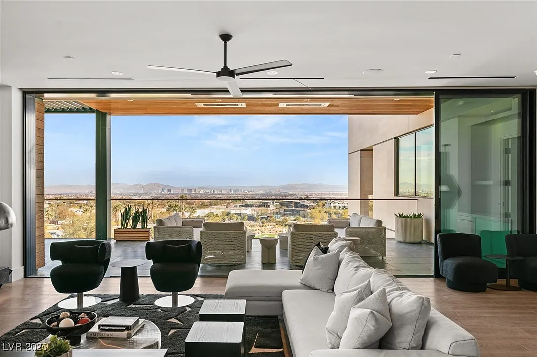 Low-profile seating sits in front of sliding glass panels that fully retract, extending the living room directly onto the terrace.