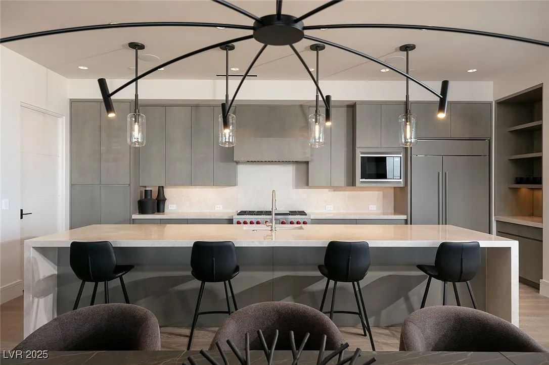 The kitchen is centered around a large waterfall-edge island with integrated bartop seating. 