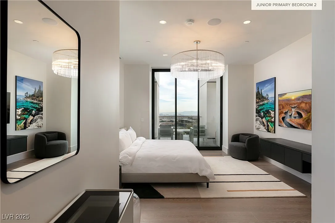The junior primary suite is centered around a low-profile bed positioned next to floor-to-ceiling glass doors that open directly to a small terrace. 