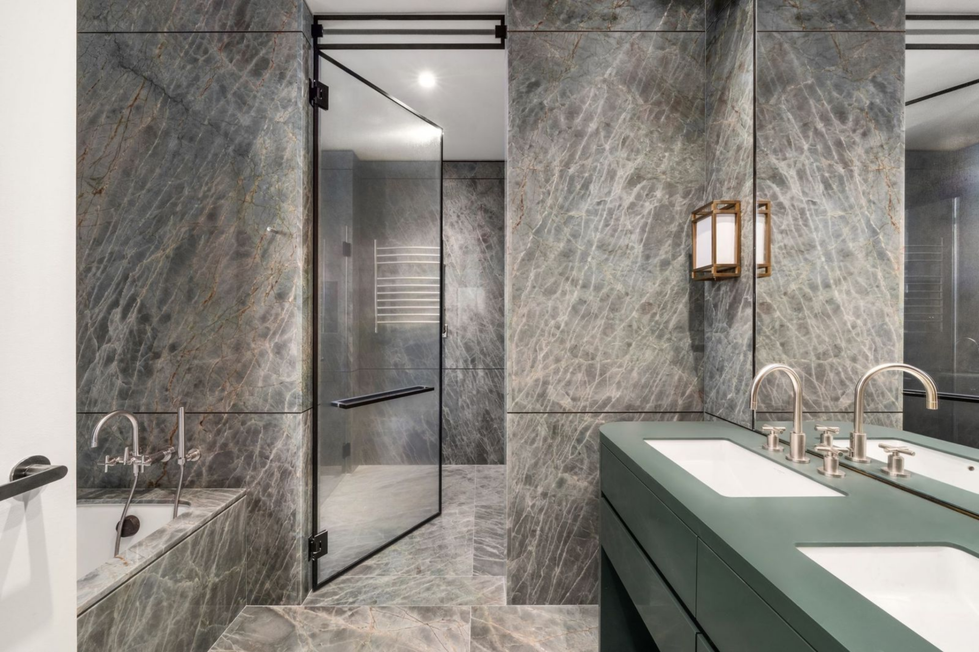 Primary bathroom is finished in Brazilian quartzite from floor to ceiling, wrapping everything from the soaking tub to the expansive walk-in shower. 