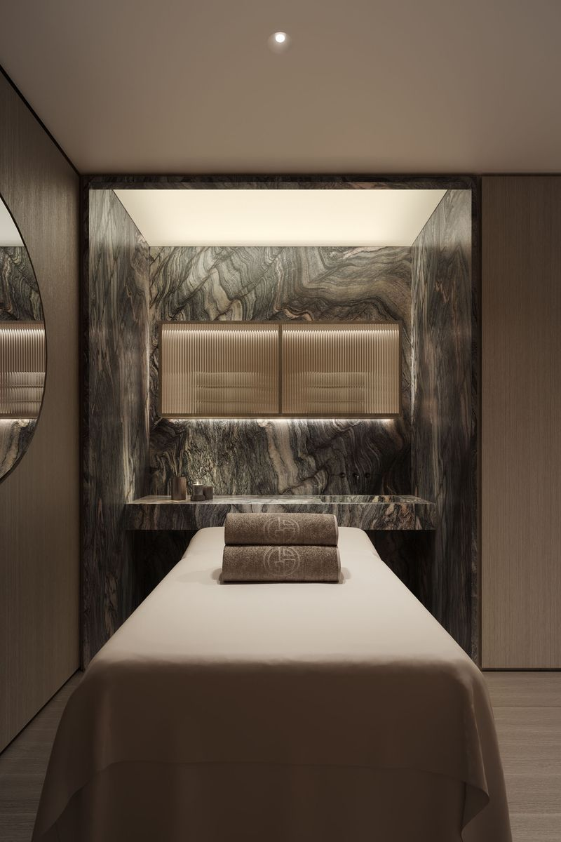 The spa treatment room is finished with rich stone surfaces and warm lighting.