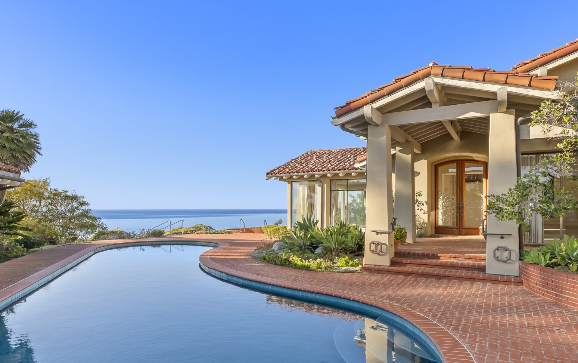 Just steps away, the pool sits next to the front door and overlooks the ocean.