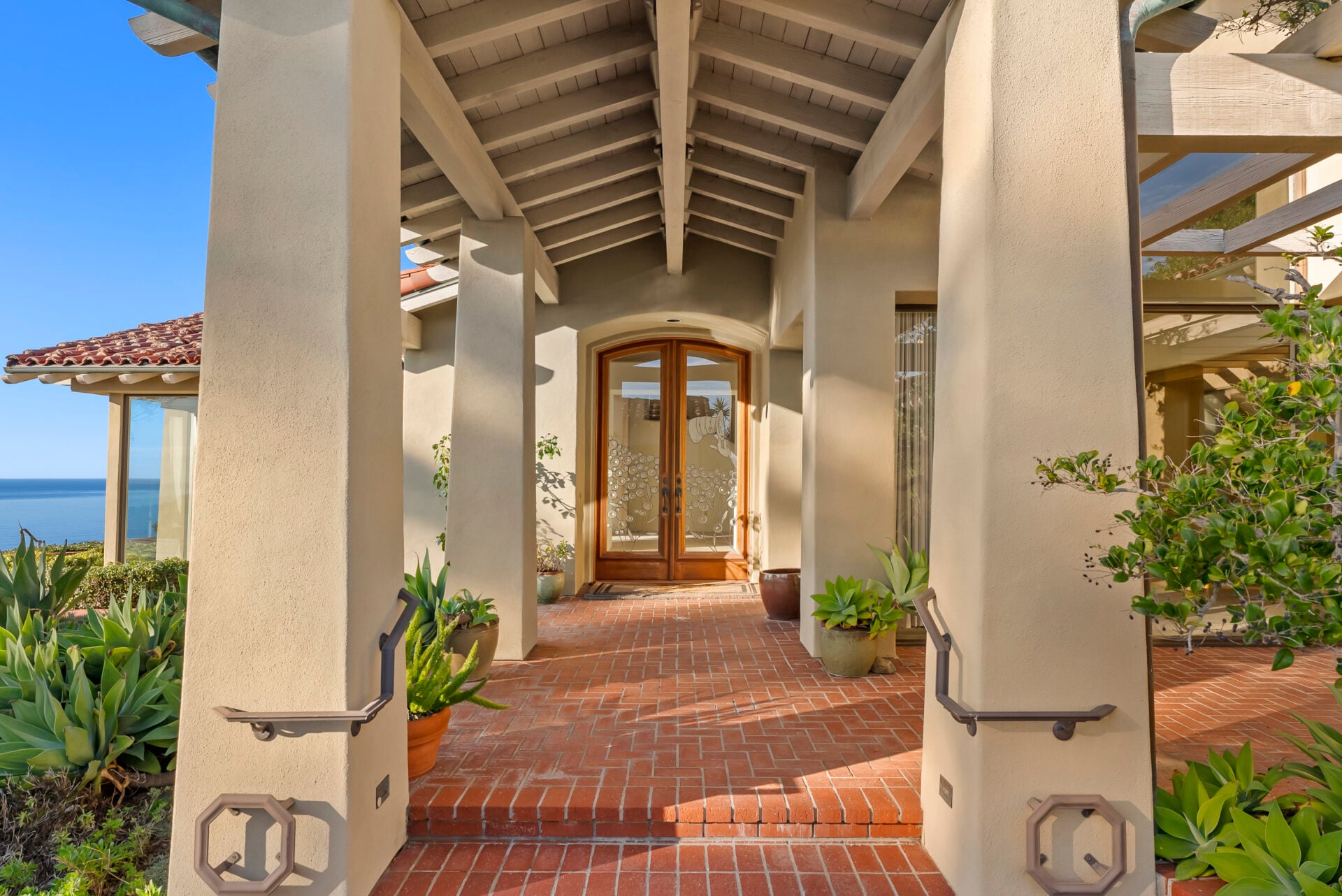 Centered beneath the exposed beam ceiling, the wood and glass front door features a subtle etched motif of The Cat in the Hat.