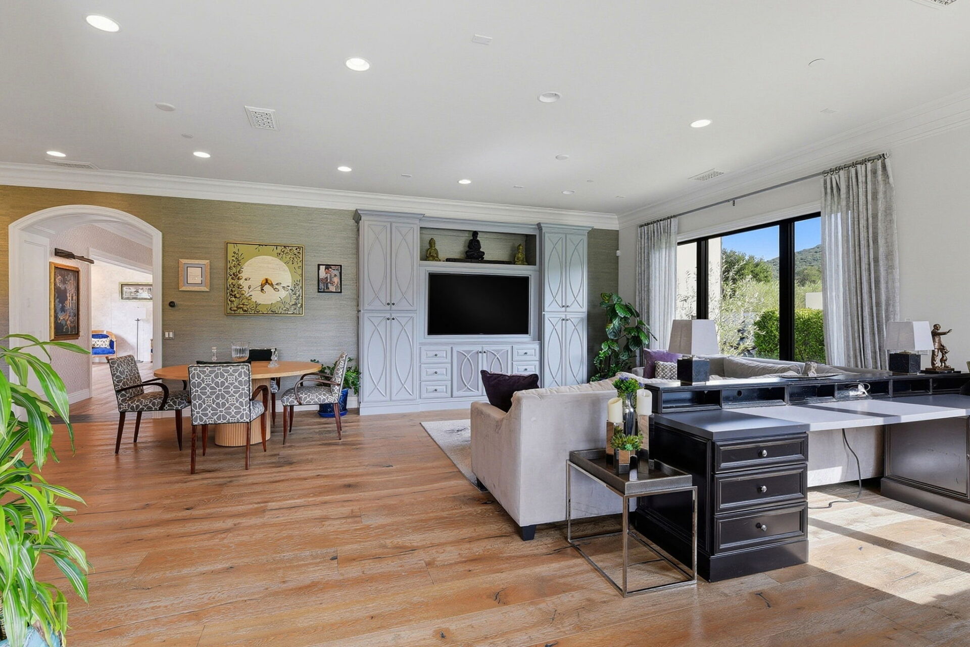 Just off the chef’s kitchen, the family room offers a more relaxed, everyday gathering space with its furniture hinting at multiple uses, including a media space, dining area, and office setup.