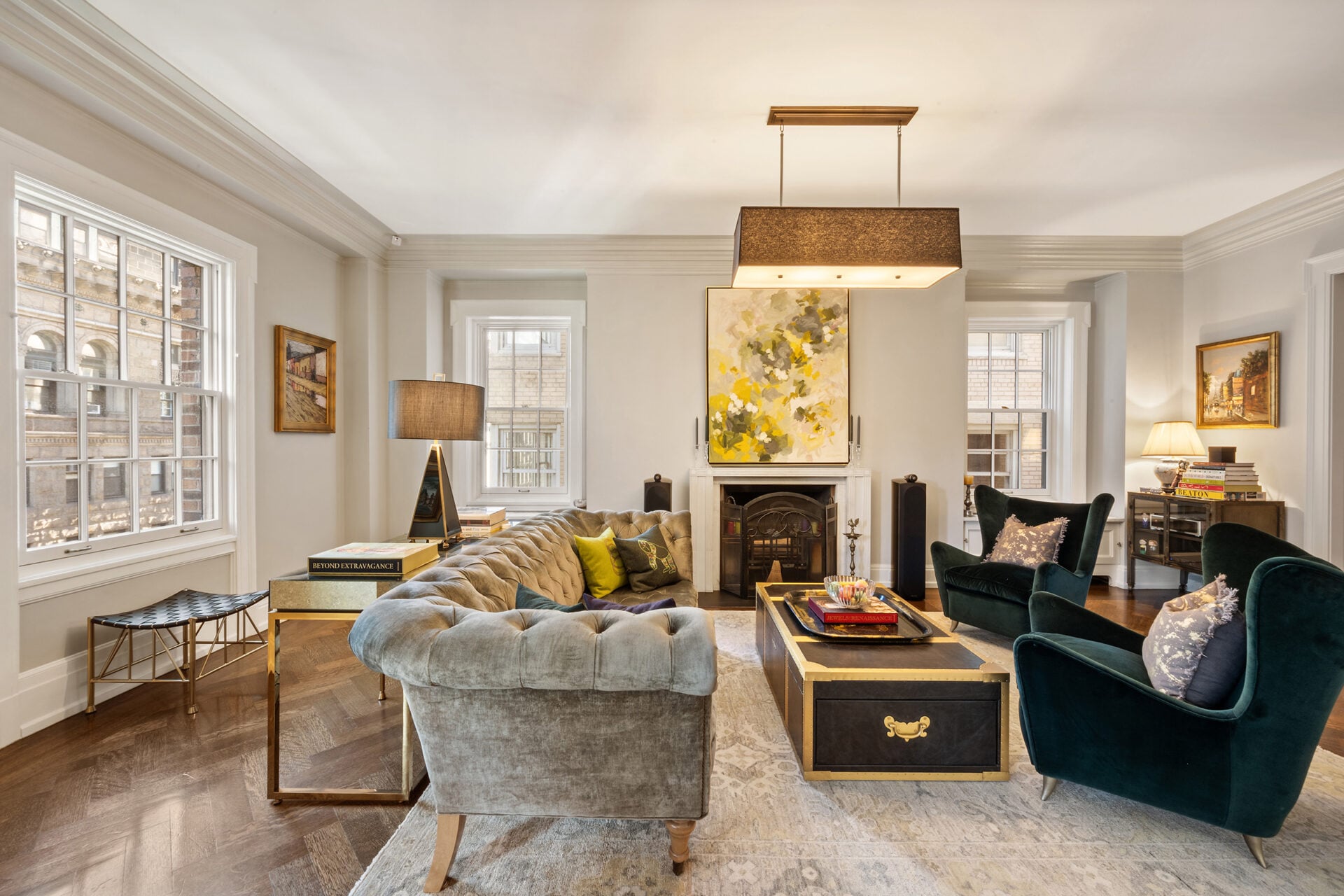 The corner living room has a wood-burning fireplace is framed with clean molding and topped by a bold, abstract canvas. 