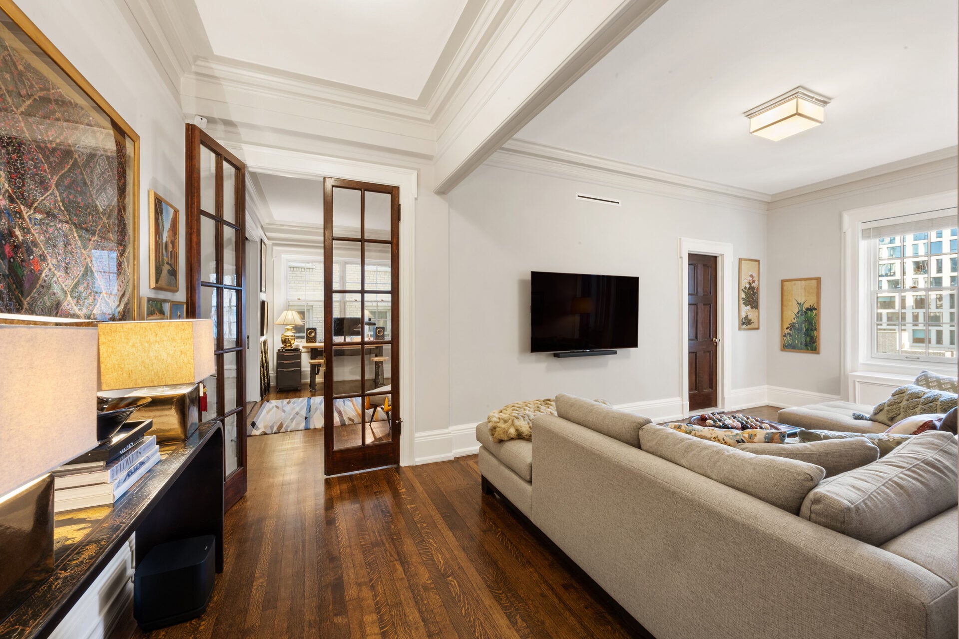 Completing the level is a relaxed media room with a deep sectional facing a wall-mounted screen.