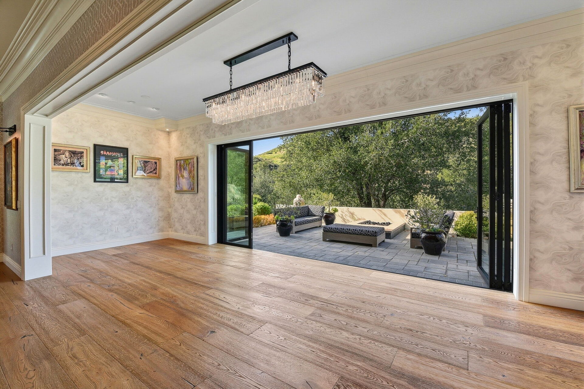 With the glass doors fully open, the terrace becomes a natural extension of the entertaining space, creating the perfect setting for cocktail hours, celebrations, or larger gatherings.