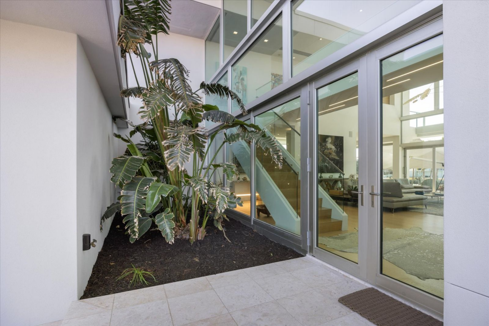 From there, the path naturally guides you to the second threshold, a full glass door that reveals the interiors beyond. 