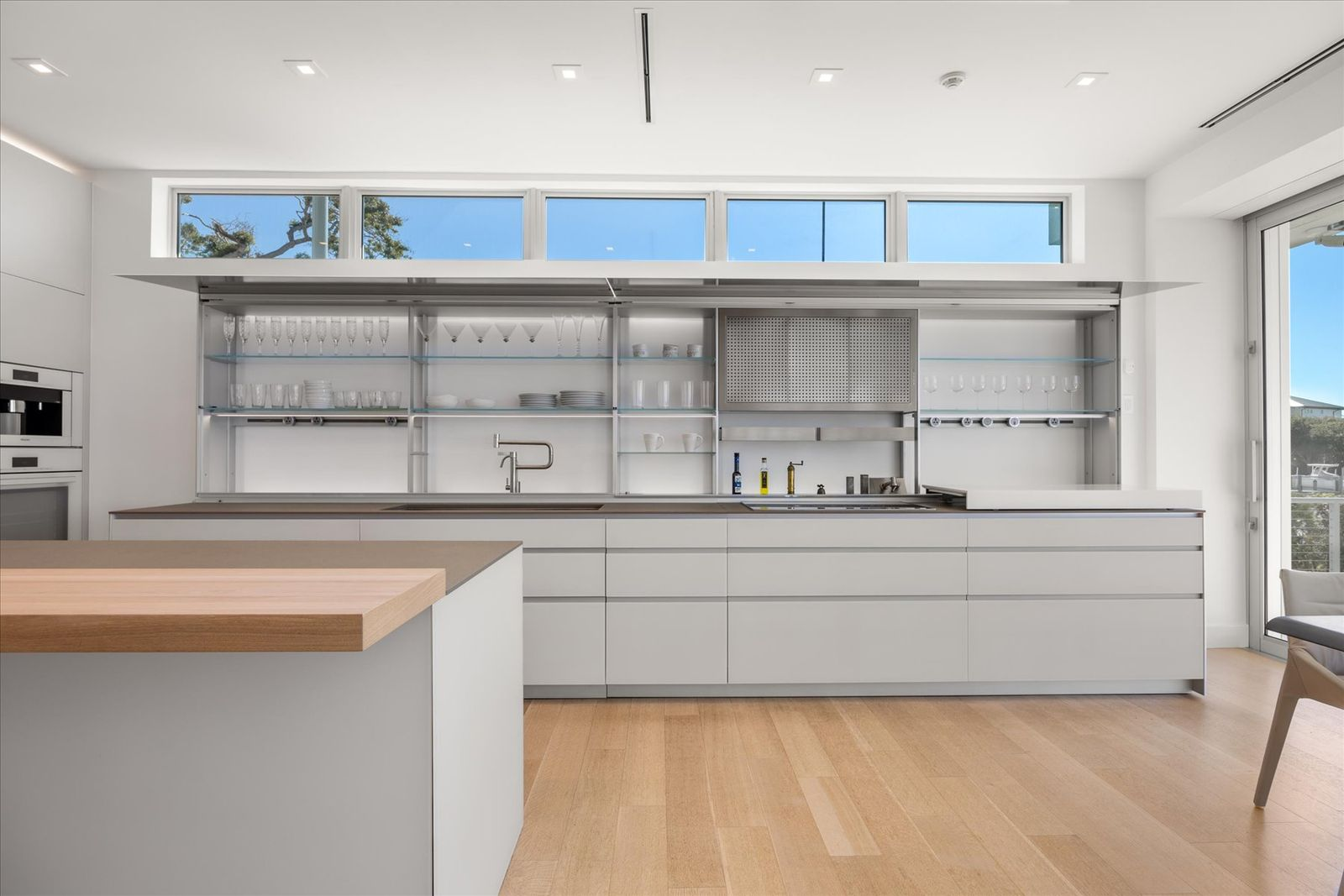 The Valcucine kitchen is designed to disappear as much as it performs, with custom cabinetry that folds away to conceal appliances and keep the room visually calm. 