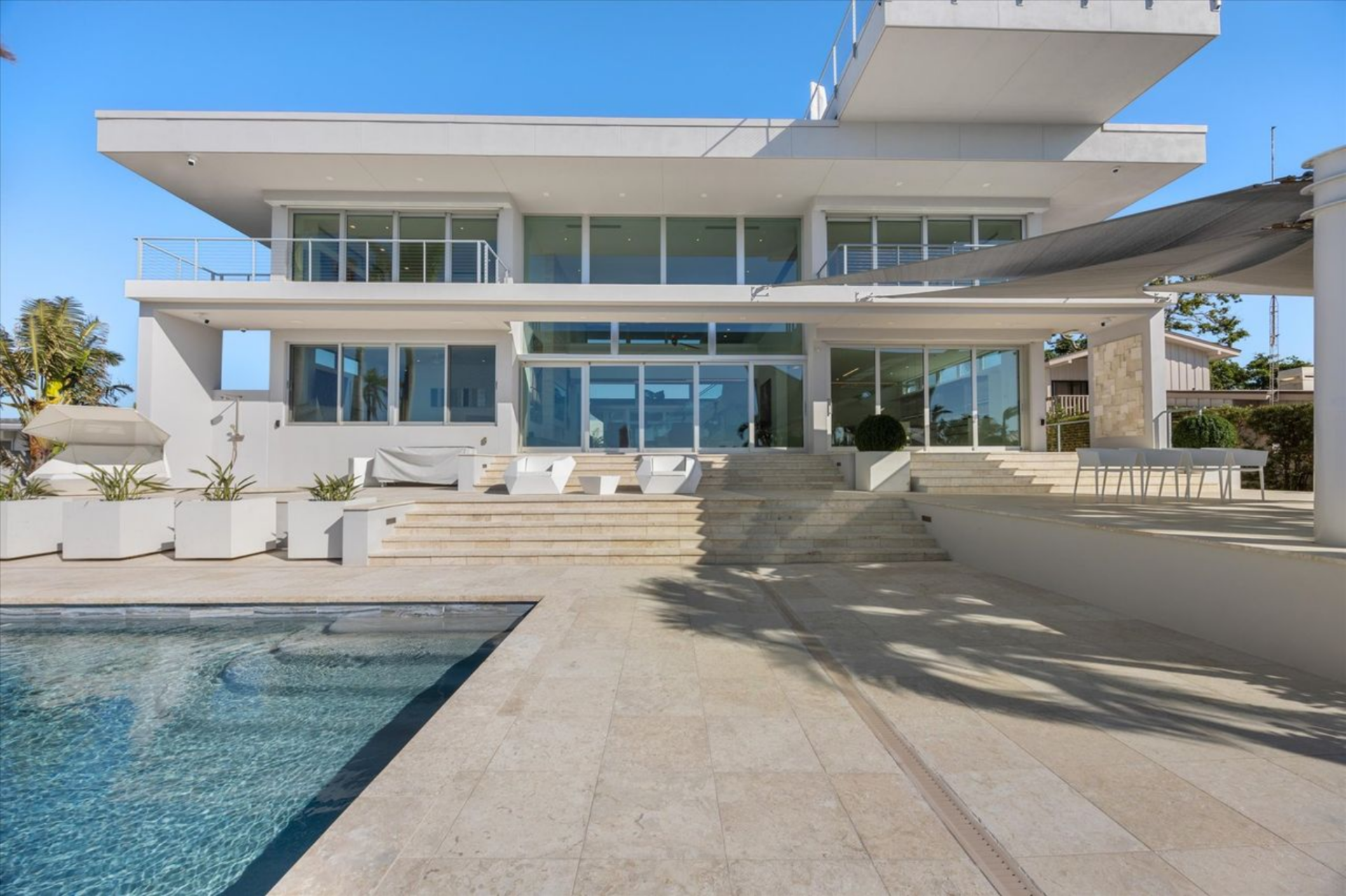 Large sliding glass doors create easy access to the deck's multiple seating zones and shaded areas, which are arranged to accommodate dining, lounging, and entertaining.