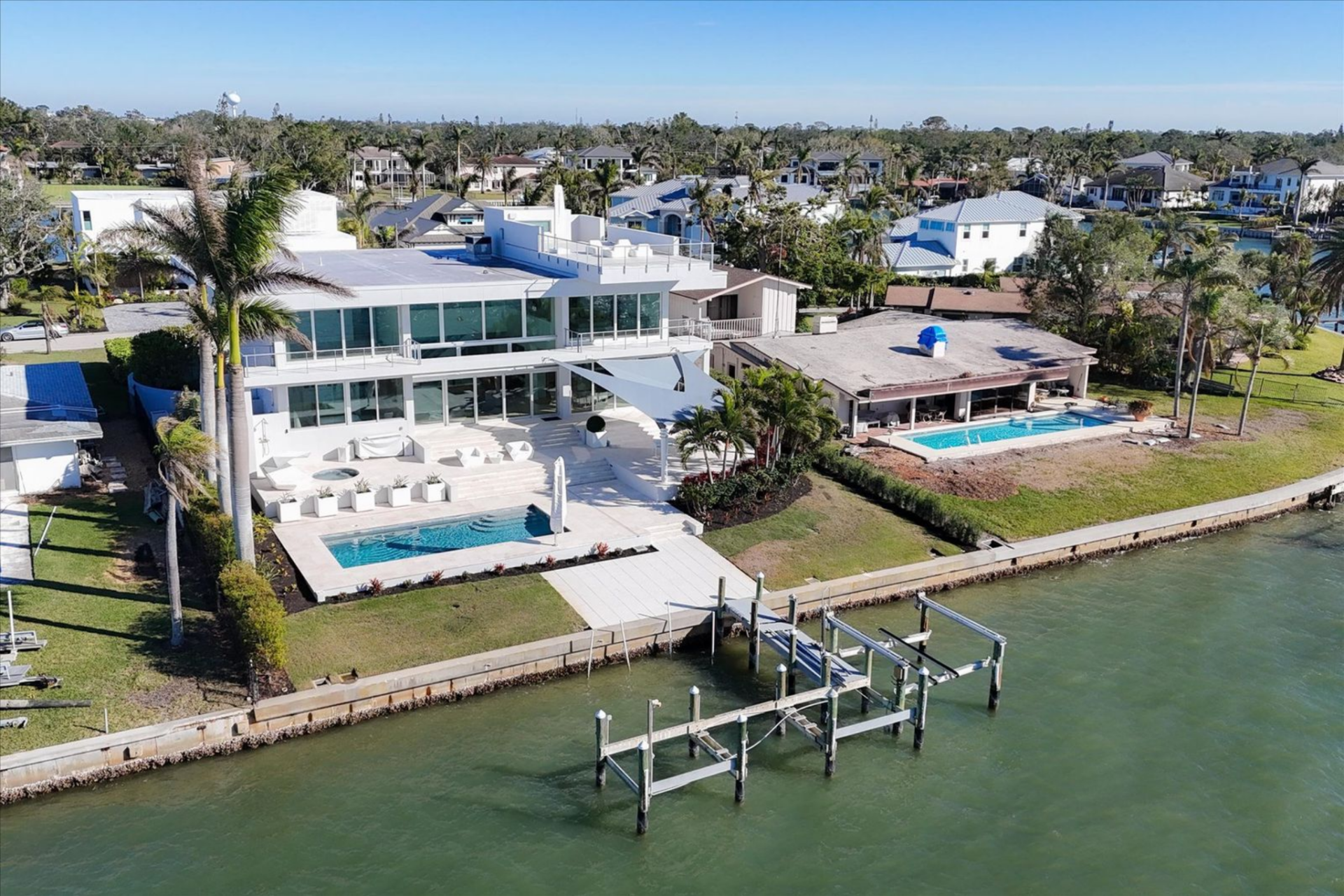 At the edge of the property, a private dock with a lift provides direct access to the water, reinforcing the home’s boating-friendly layout. 