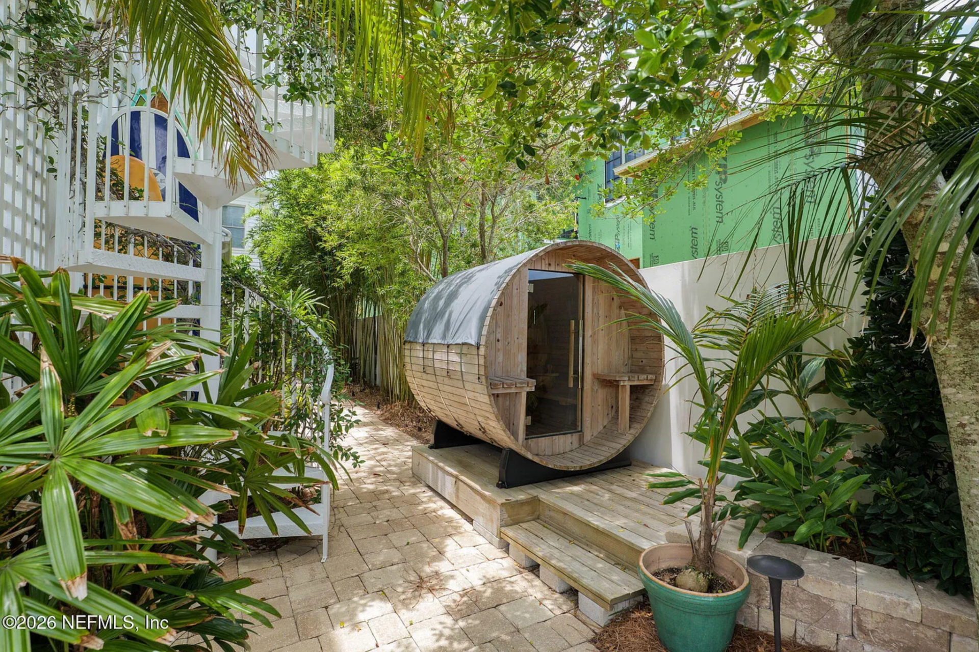 Tucked within the landscaping, a barrel-style sauna adds a dedicated wellness element to the property.