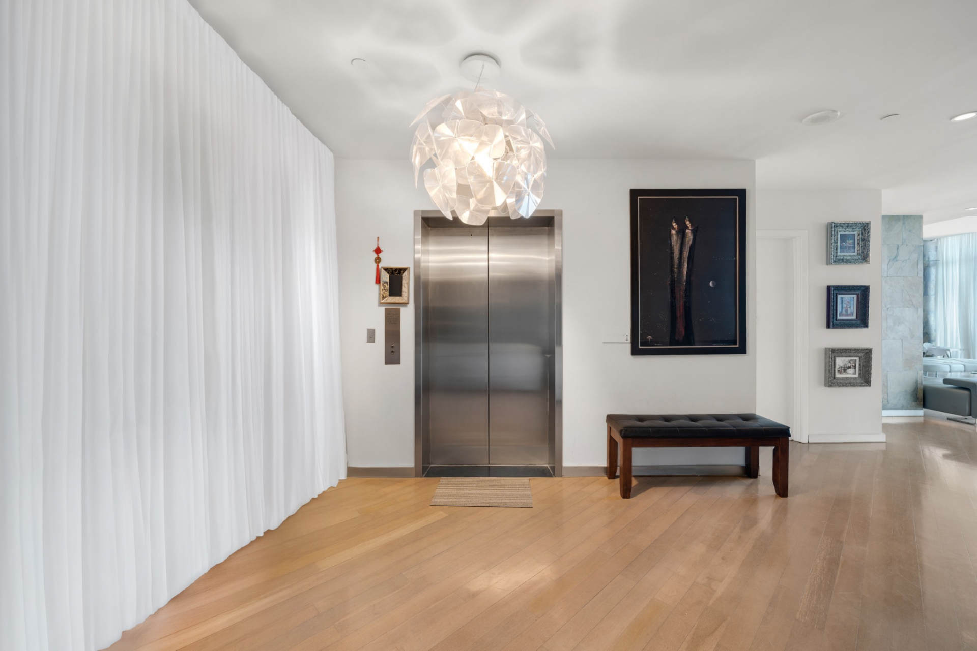Entry into Luis Miguel’s former Miami penthouse begins directly from a private elevator, which opens into a foyer framed by wide-plank wood floors and a sculptural pendant overhead. 