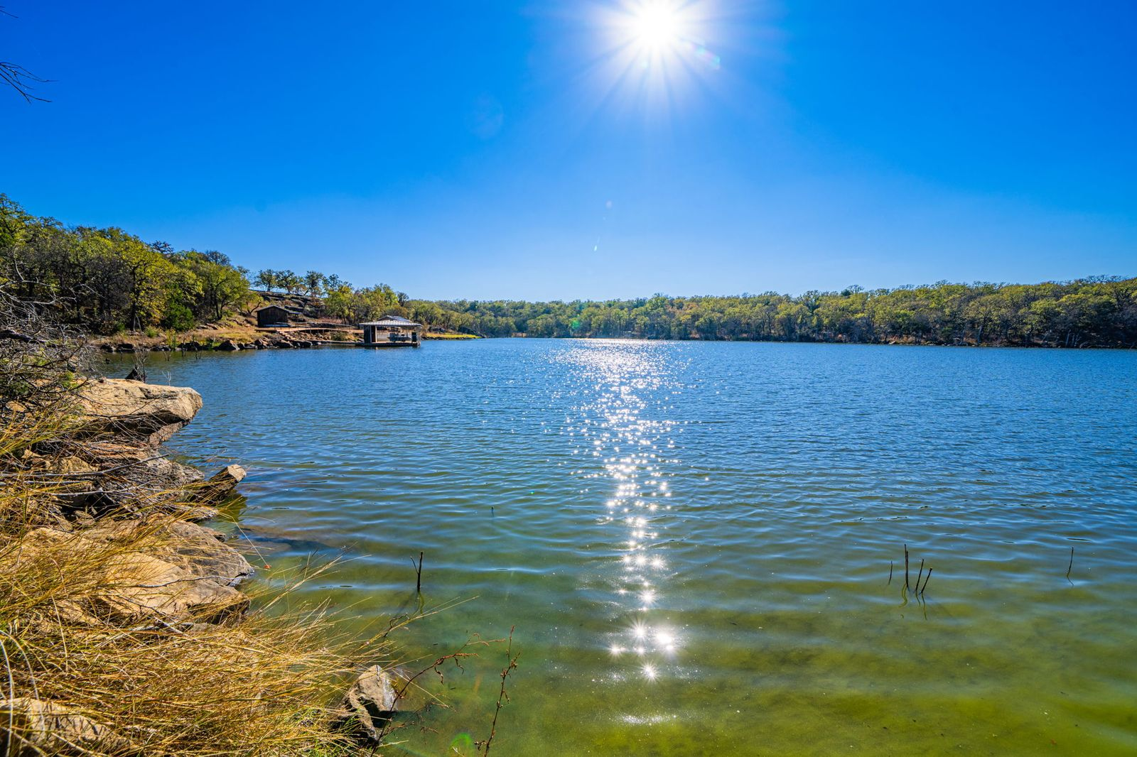 Fishing and boating pond surrounded by trees and rock formations.