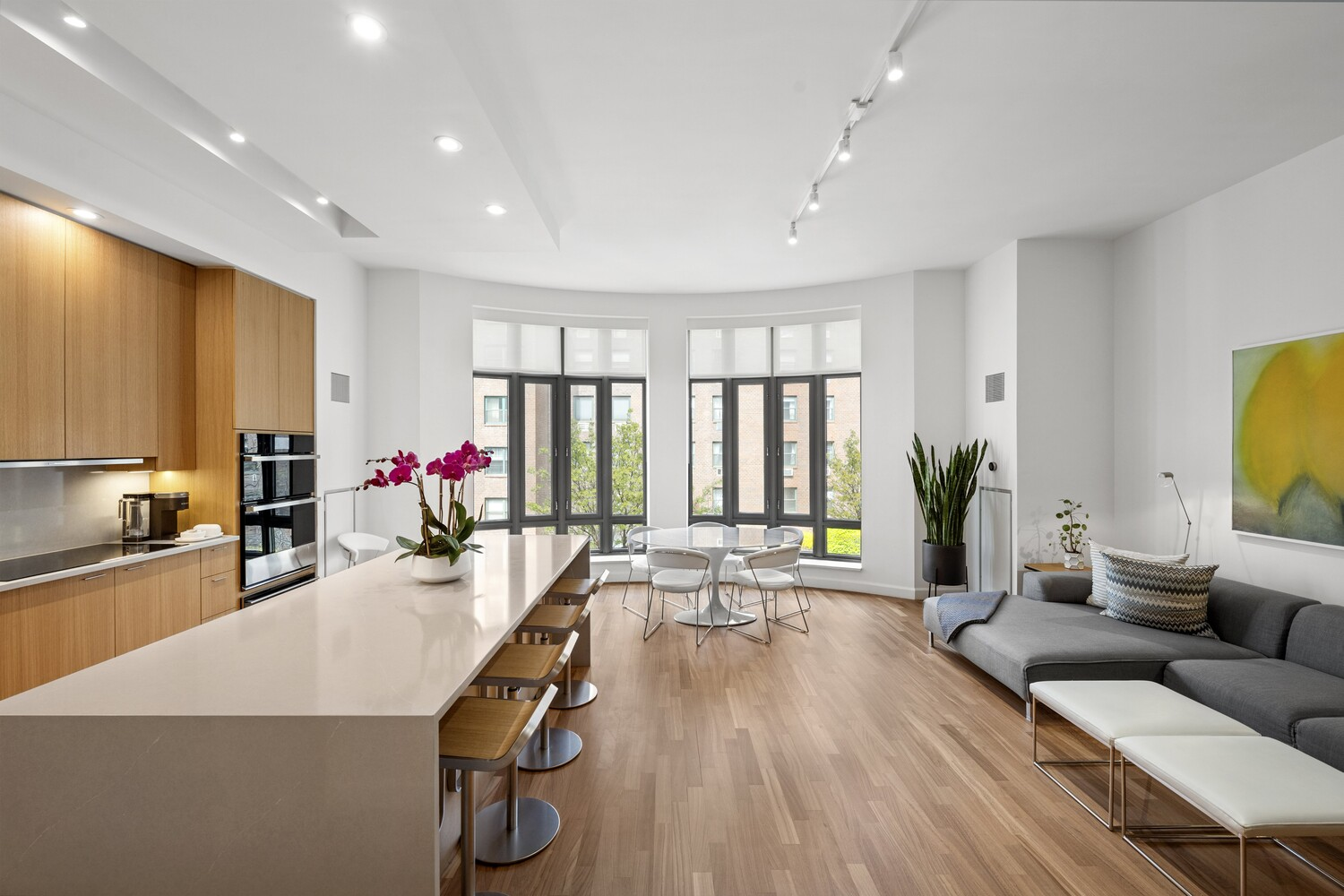 At the opposite end of the second floor, the kitchen and family room unfold as a single, open zone connected by a bowed wall of floor-to-ceiling windows. 
