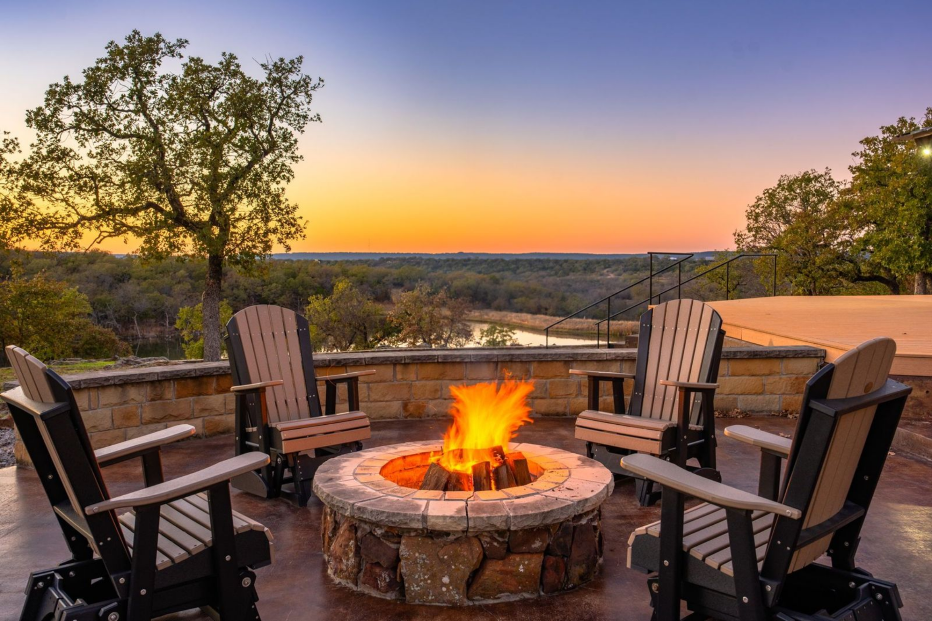 Positioned closer to the water’s edge, a circular stone firepit is set up for sunset views across the lake.