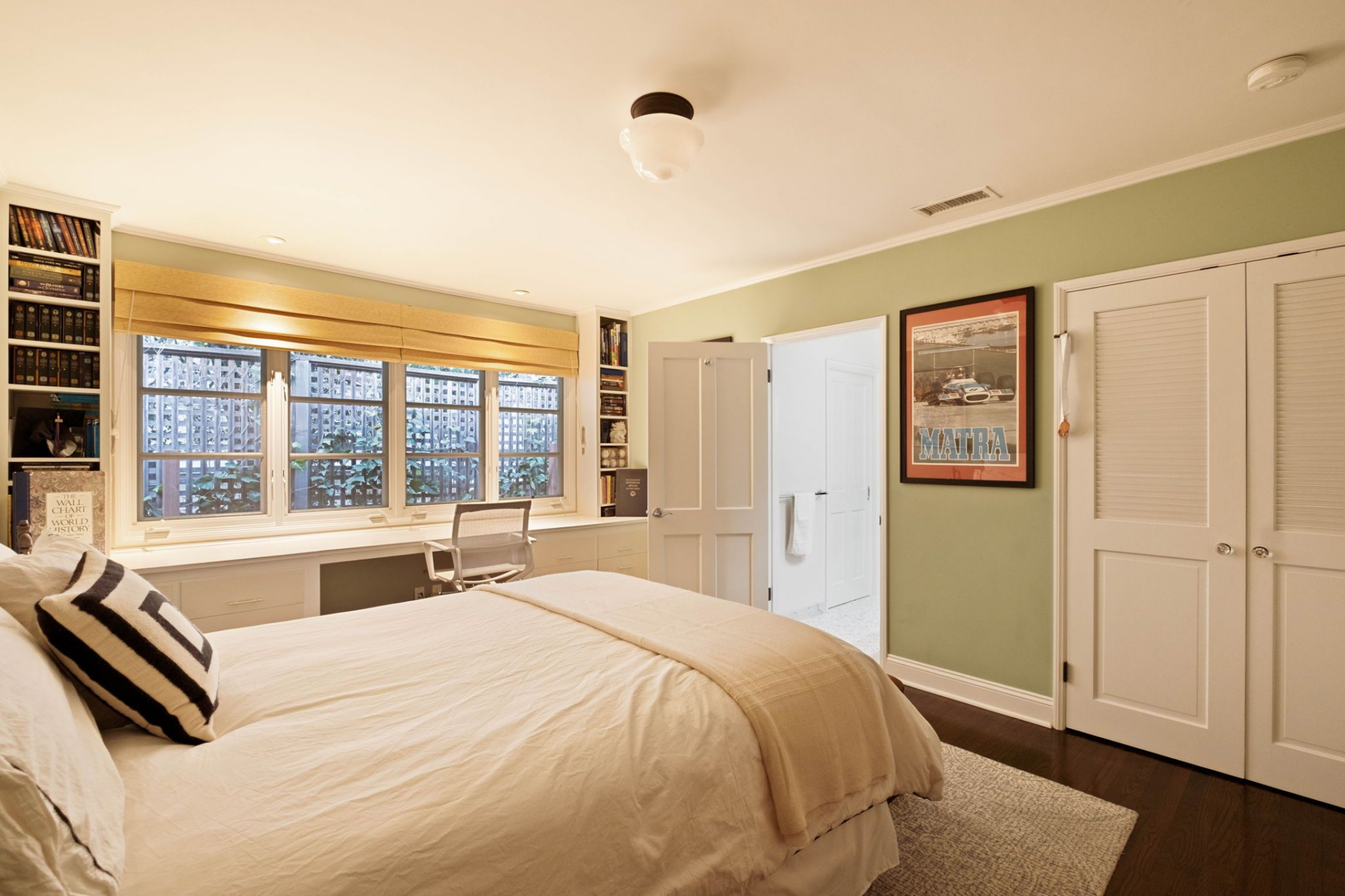 Storage is thoughtfully integrated, from the louvered closet doors to the custom bookcases tucked into the corners. 