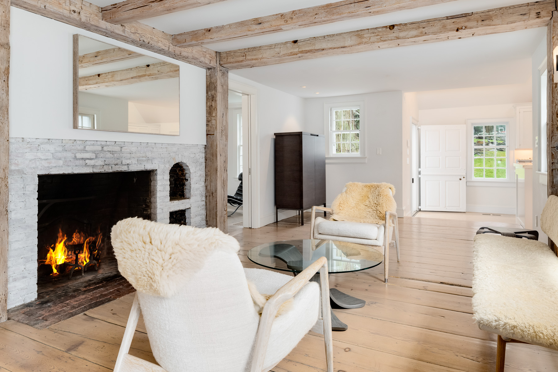 The preserved fireplace, with an almost identical design to the one in the living room, creates the family room side, where simple seating is arranged to face the hearth.