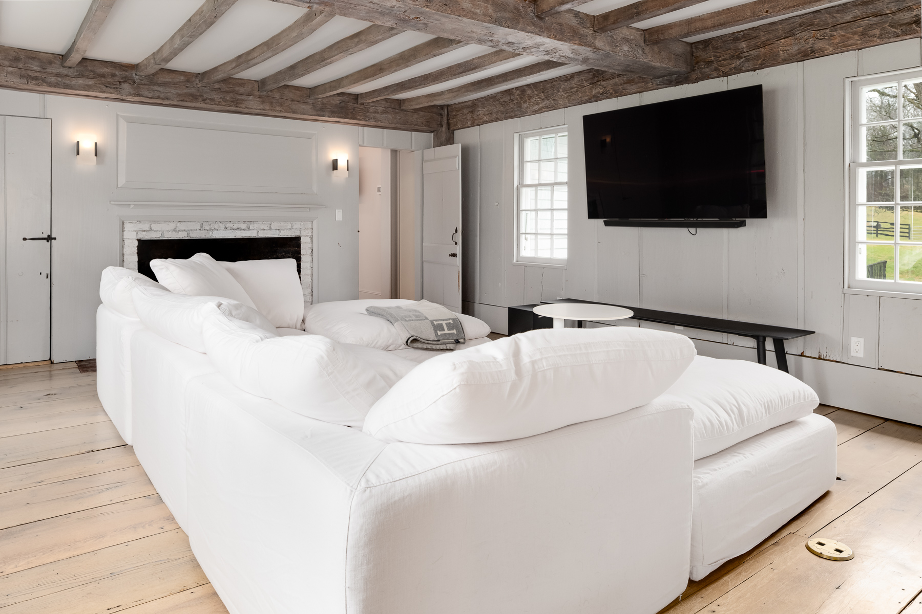 The media room leans into the farmhouse aesthetic with a deep, oversized sectional that faces a mounted flat screen TV.