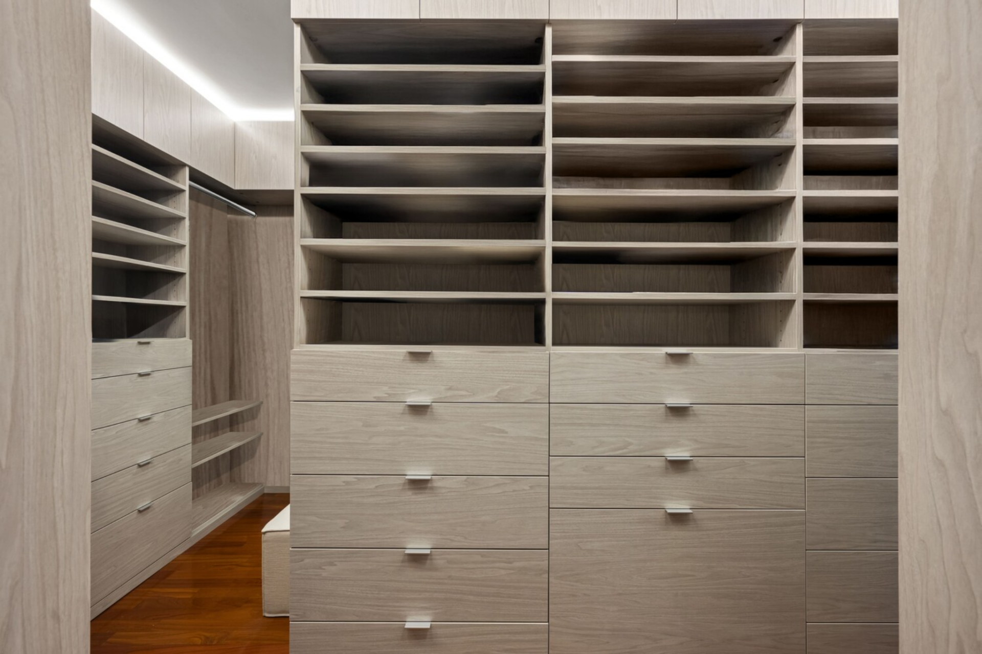 Custom-built closets are integrated into the suite, offering floor-to-ceiling storage that provides a variety of drawers, shelving, and hanging racks.
