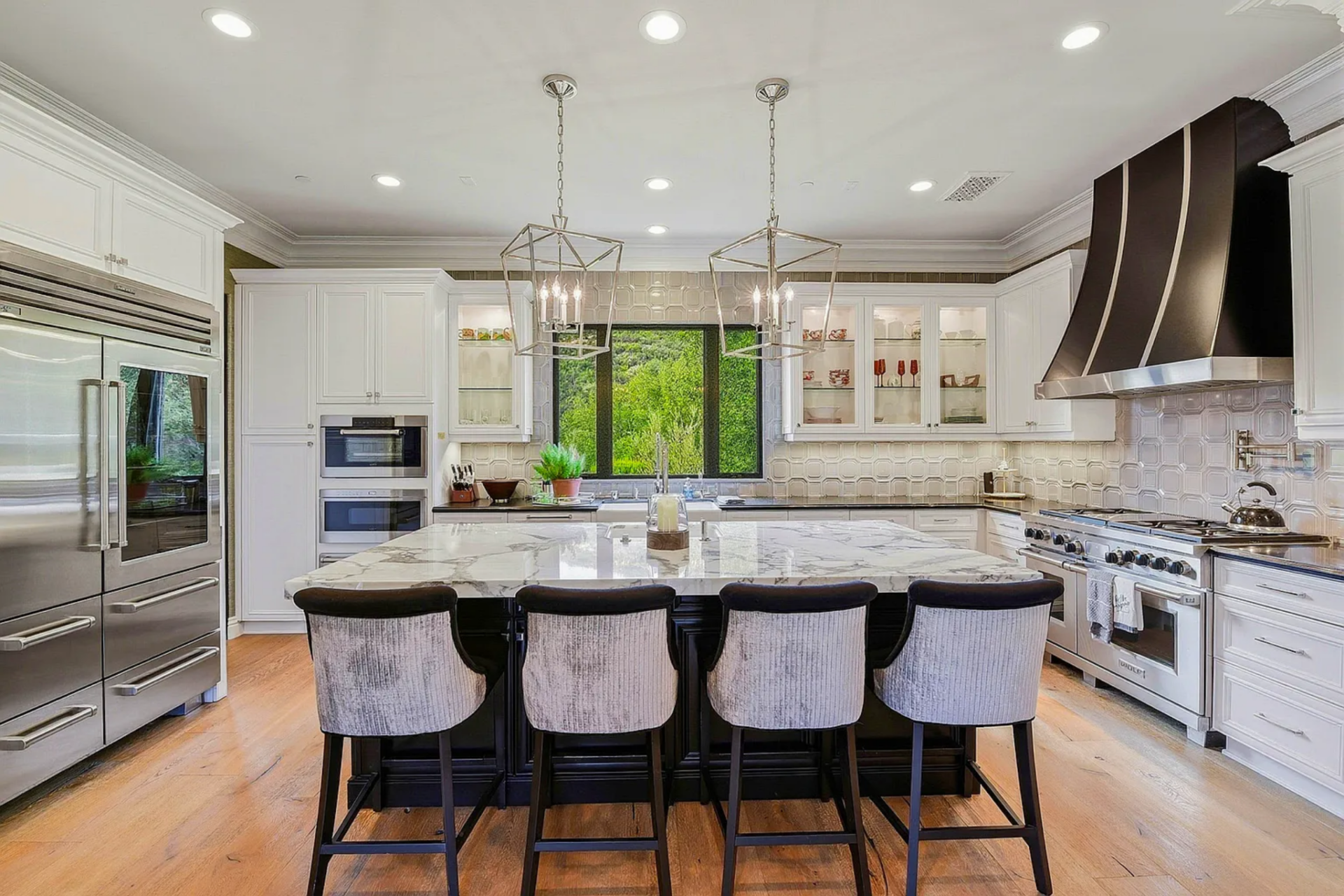 The chef’s kitchen includes a large marble waterfall island, premium Wolf cooking appliances, a Sub-Zero refrigerator, and ASKO dishwashers, delivering the kind of professional-grade functionality expected in a home built for entertaining. 
