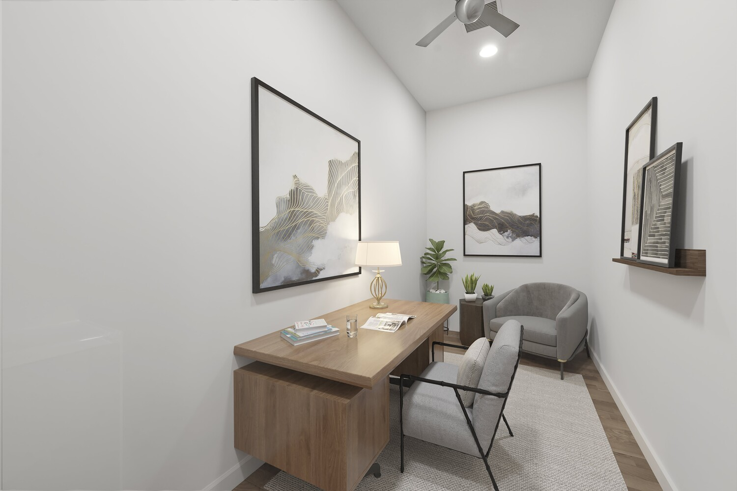 A wood desk is positioned lengthwise against the wall, with space for a desk chair and a secondary lounge chair tucked into the corner.