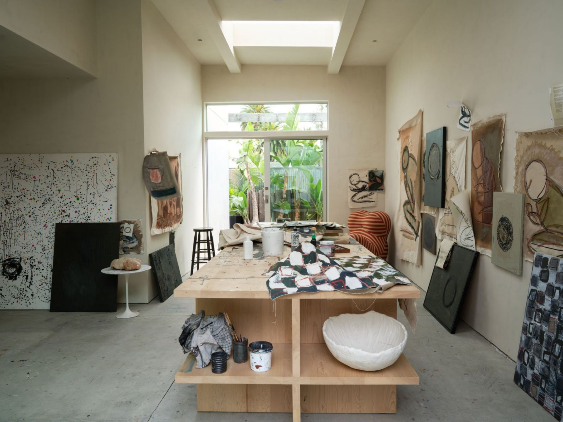 Set apart from the main living areas, the design studio is flooded with natural light that brighten the tall, gallery-like space, while smooth plaster walls serve as a neutral backdrop for looking at works in progress at another angle.