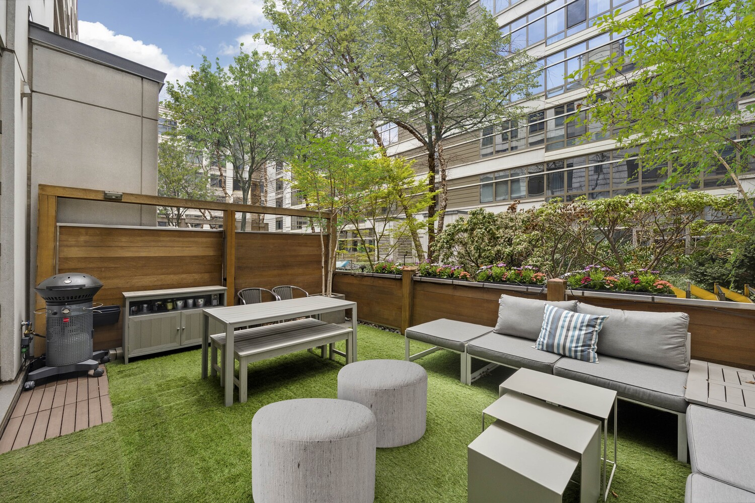The terrace looks out onto the building’s landscaped courtyard below, with trees and other plants softening the surrounding glass and stone architecture.