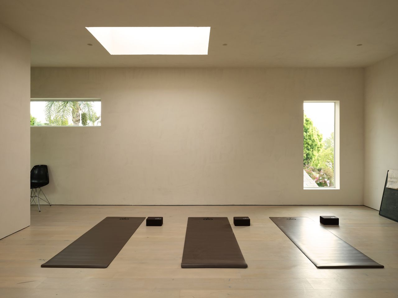 Upstairs, the yoga studio is set beneath another of the home's large skylights that washes the room in soft natural light. 