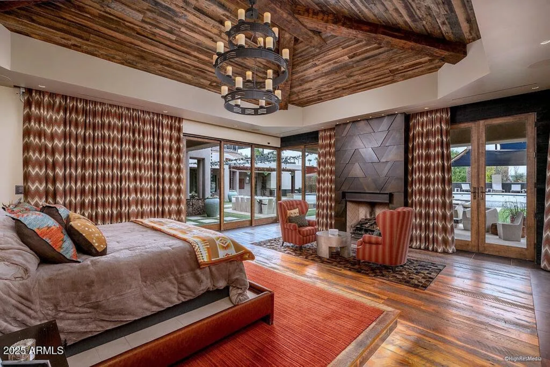 Entering the bedroom, the bed is positioned to take full advantage of the walls of glass, where doors open directly to the backyard and pool area.