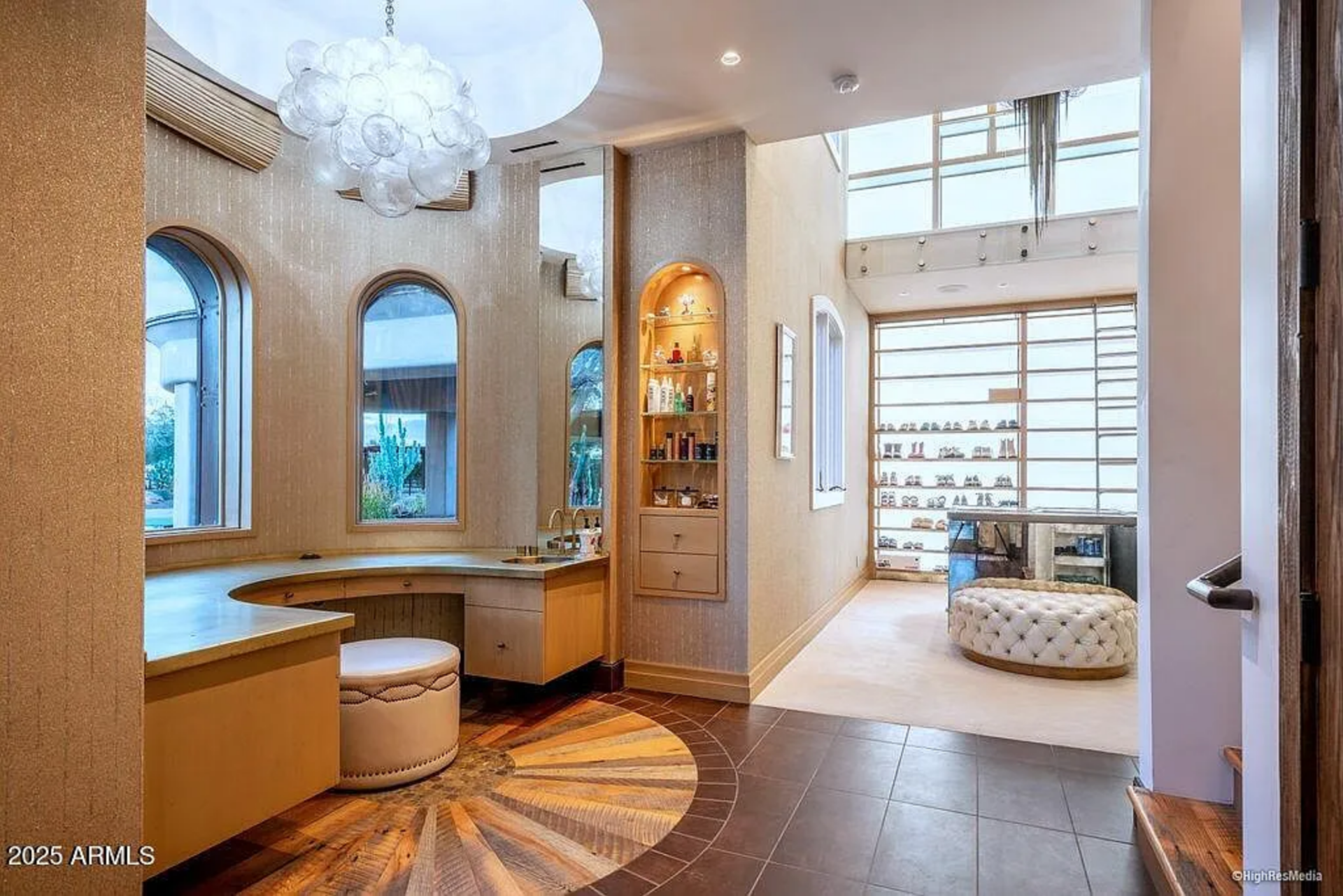 The first section features arched windows, a built-in vanity beneath a sculptural chandelier, and illuminated display niches for accessories and beauty products.