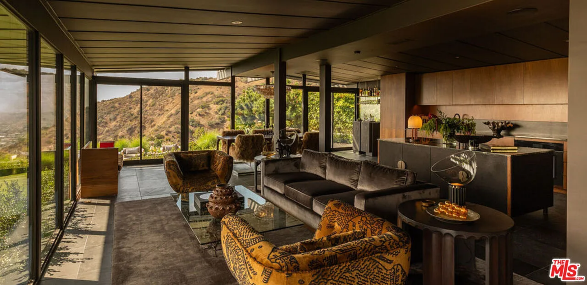 Inside Shaun White’s former Hollywood Hills home, the main living spaces unfold in a single, open layout that stretches along a wall of floor-to-ceiling glass.