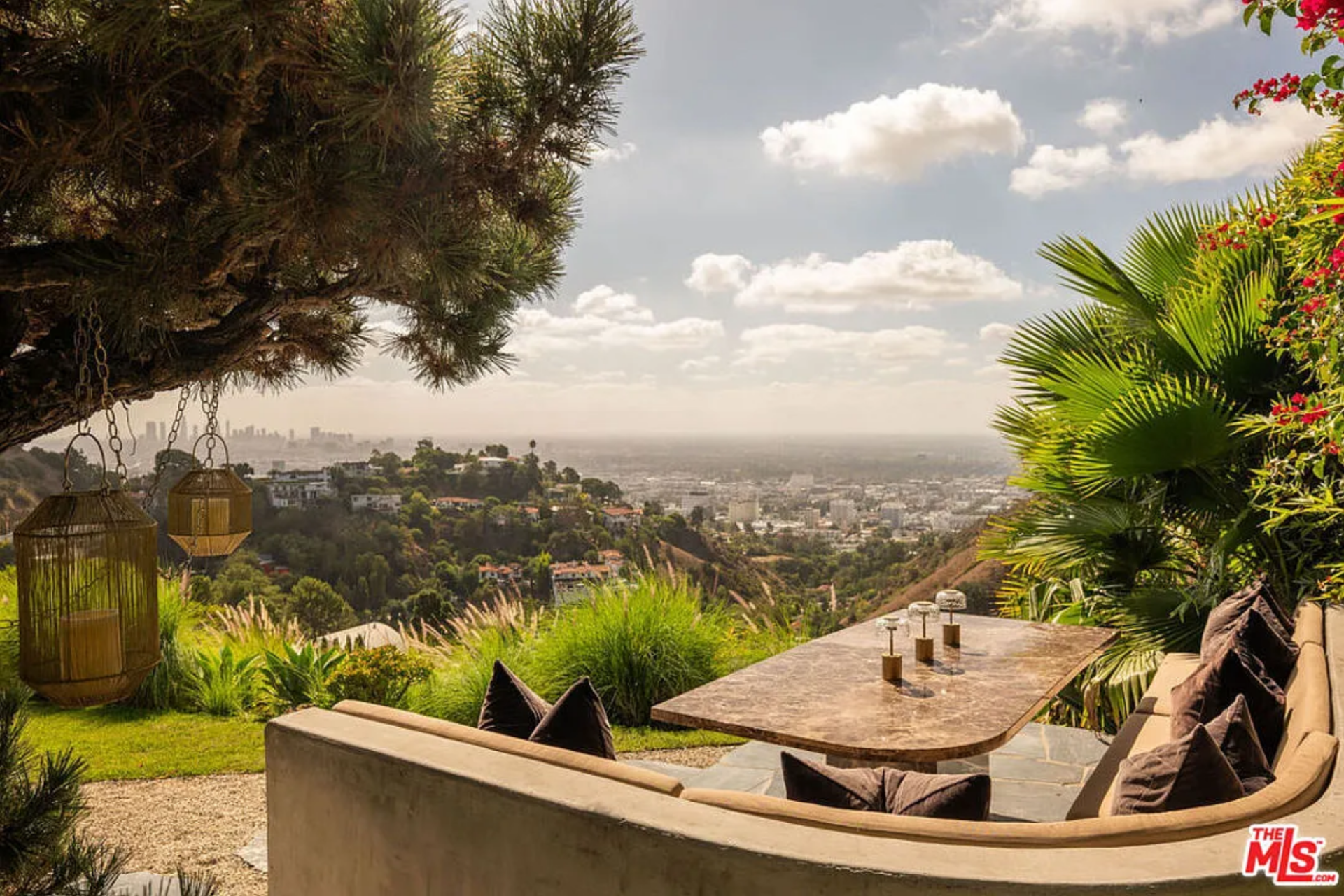 Tucked beneath hovering trees and surrounded by sculptural greenery, the built-in seating is oriented directly toward the skyline, turning everyday meals into a front-row vantage point over LA.