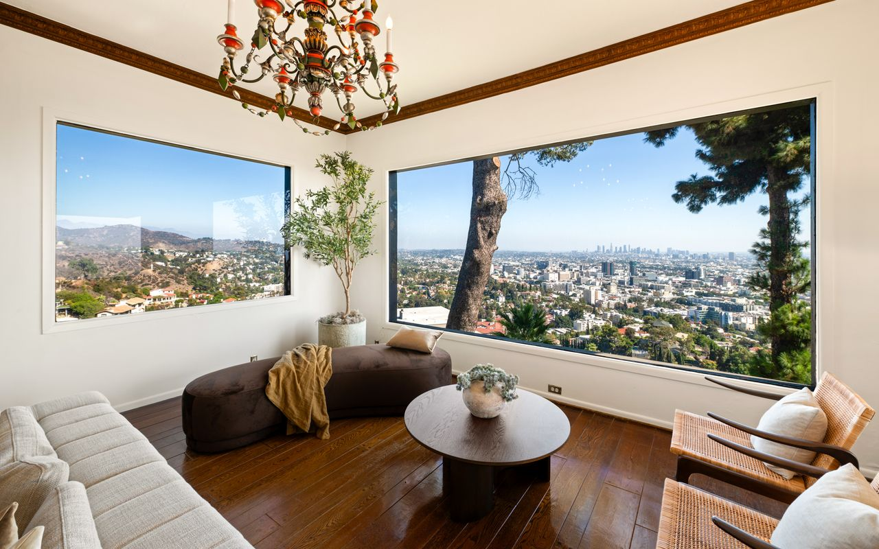 At the far end, oversized picture windows frame a sweeping city view.