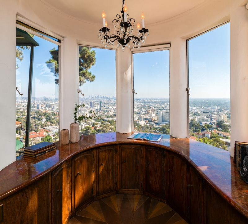 A built-in bar sits in the corner of the parlor, its cabinetry rich and polished, positioned to serve guests without disrupting the flow of conversation.