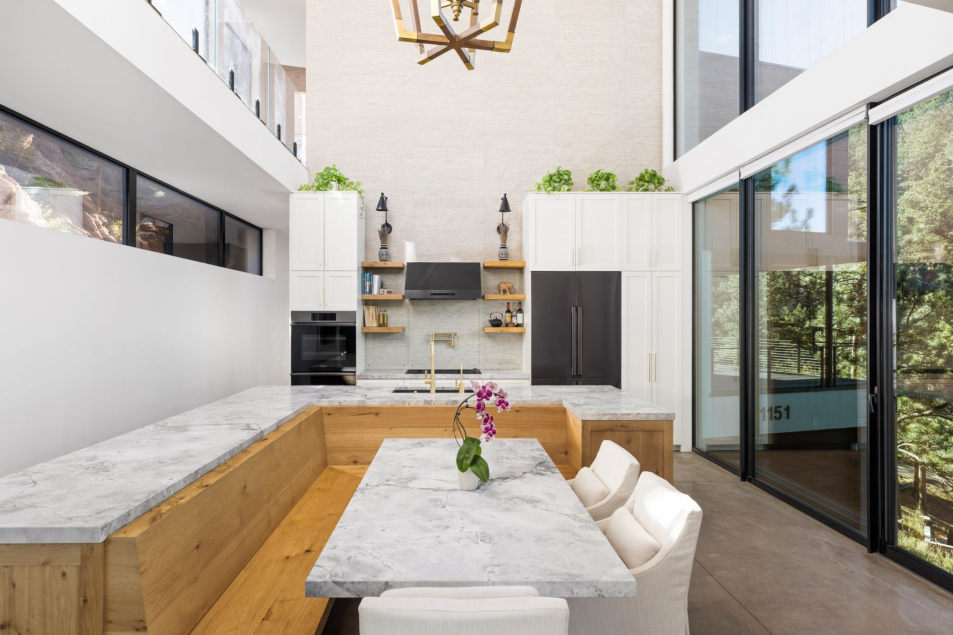 Wrapped in white cabinetry, the island features waterfall stone edges, integrated storage, and seating.
