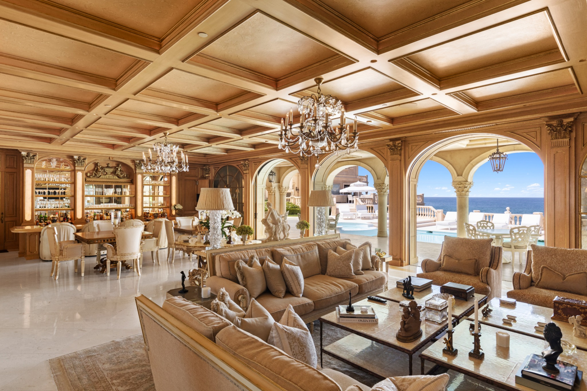 Within the same open-floor plan, a dedicated bar and entertainment area is built into the wall with various dining tables, creating a focal point for hosting.