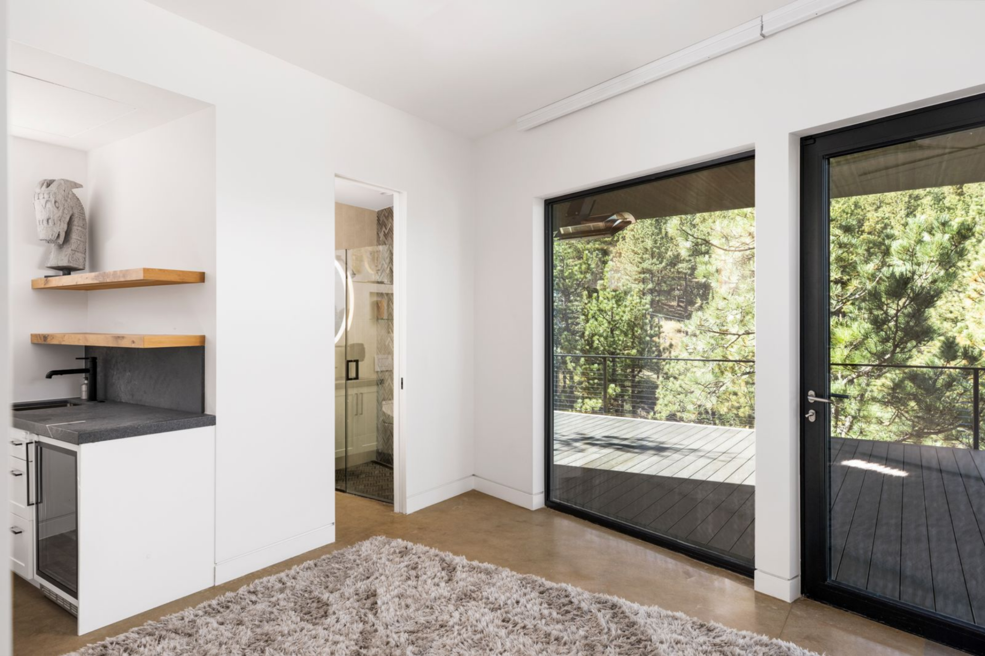 Large glass doors draw in natural light and open directly to a private patio, extending the room outdoors. 